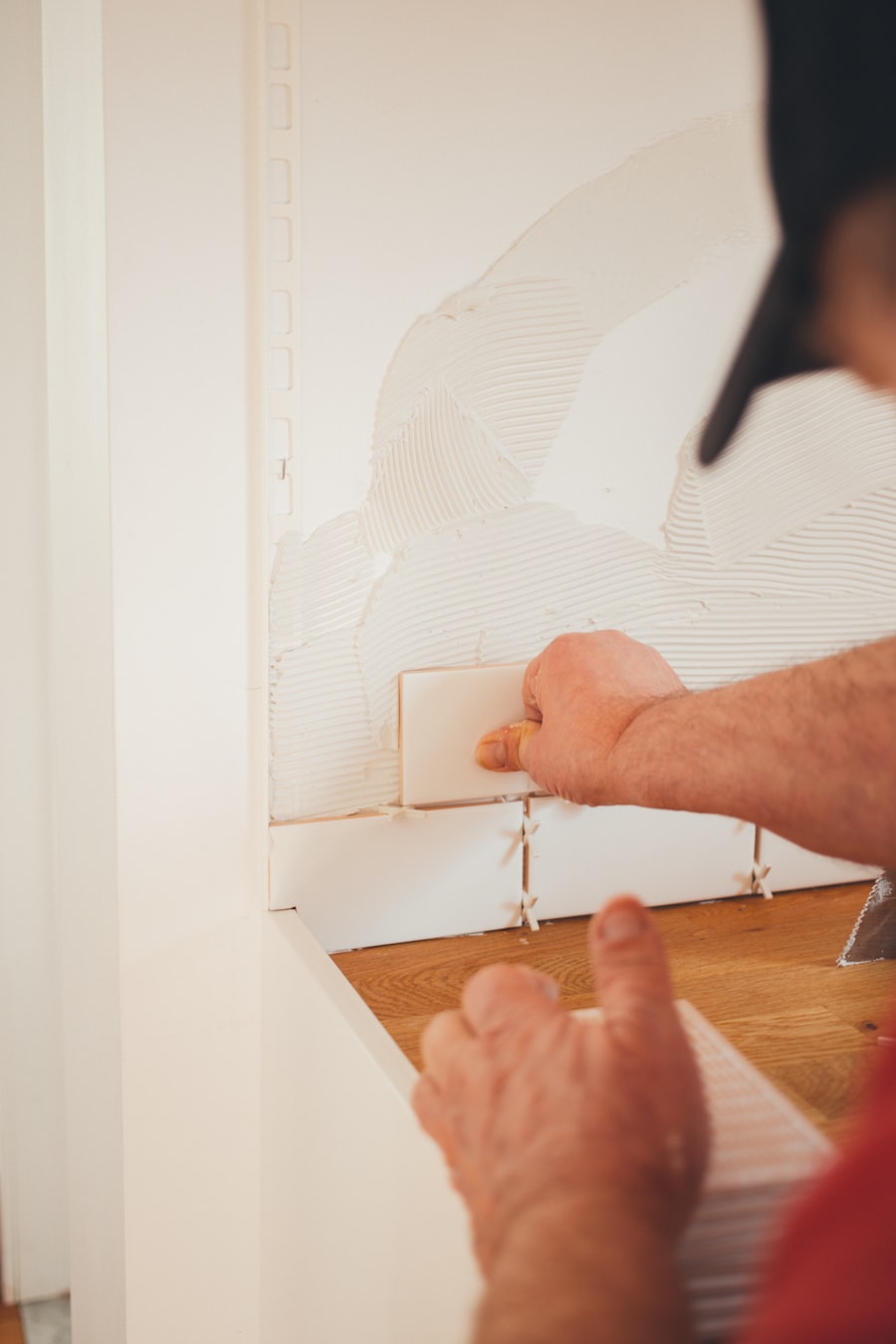 Setting a wall tile by hand